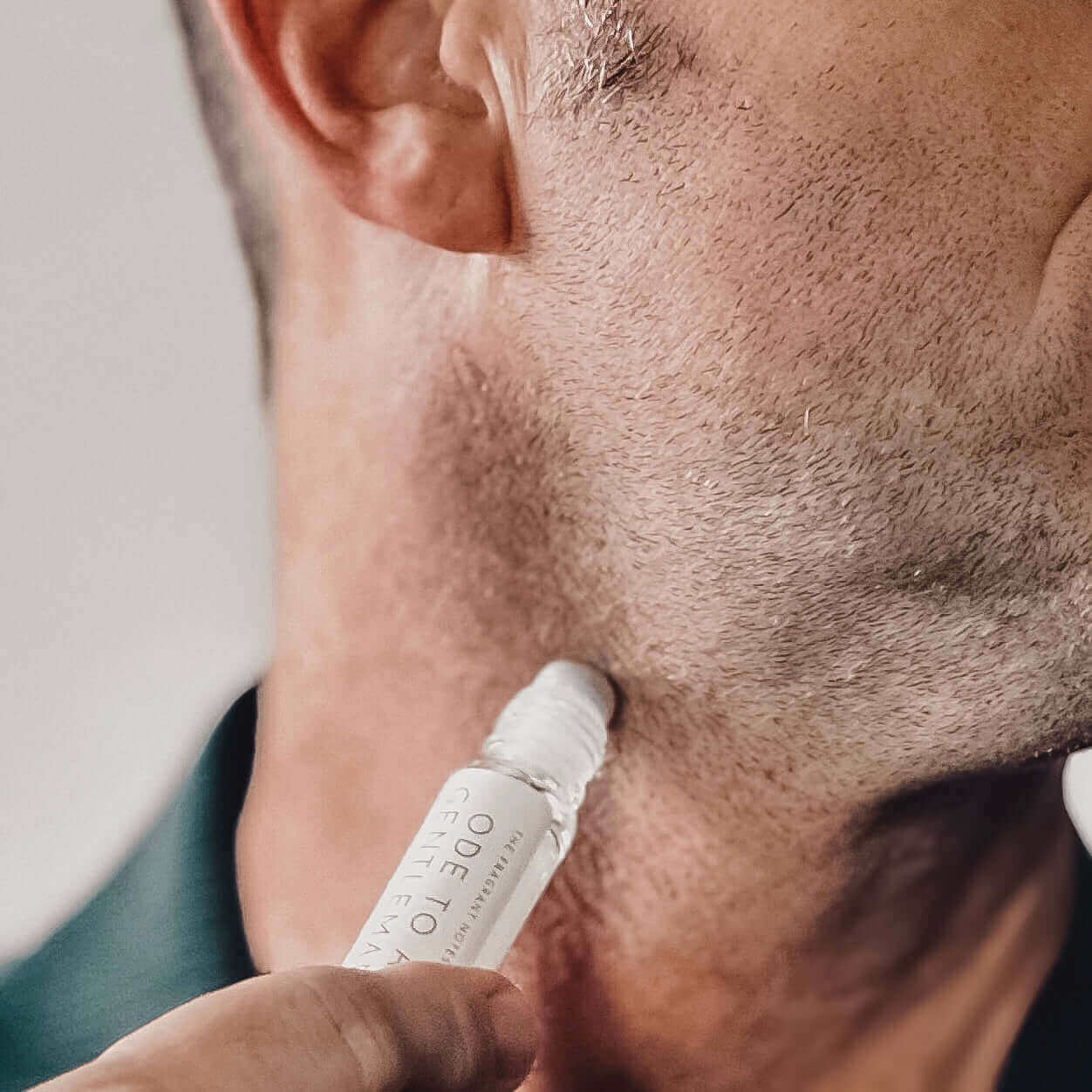 Up close of man using Perfume Oil for Men - Ode To a Gentleman Roll-On Fragrance on his neck.