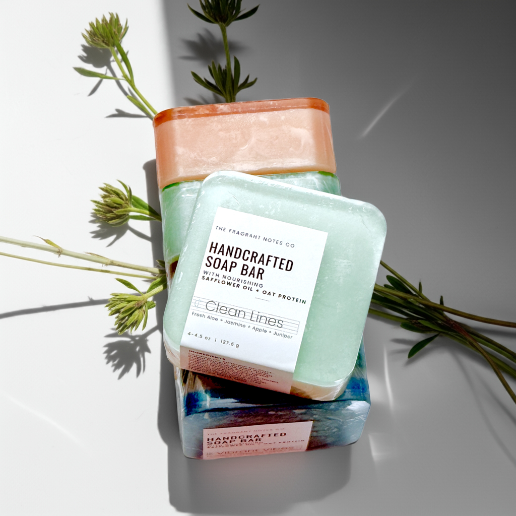 A collection of beautifully crafted natural body soap bars by The Fragrant Notes Company with greenery