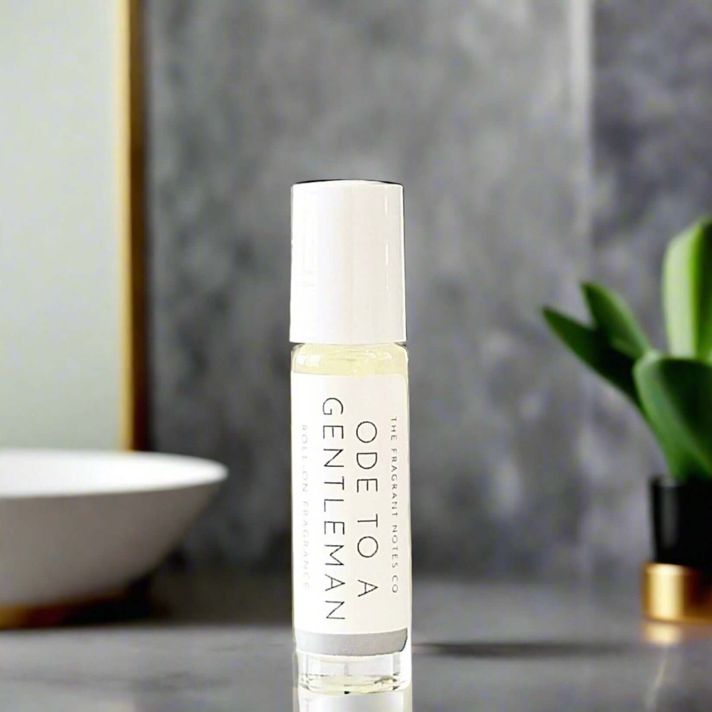 Ode To a Gentleman Roll-On Fragrance on a marble grey bathroom countertop.