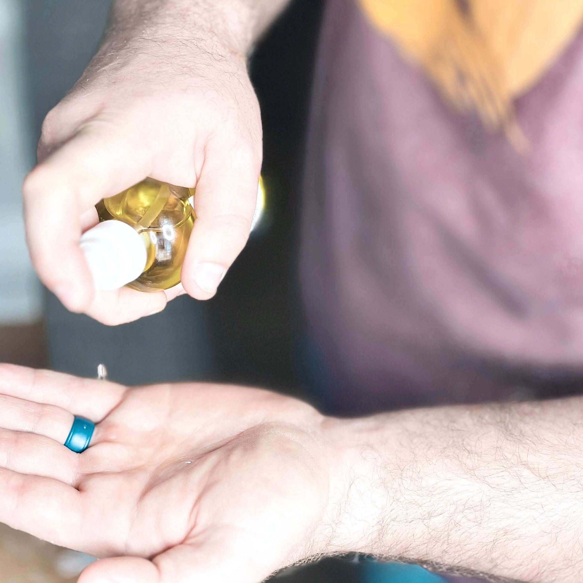Man pumping our Body Oil Serum into his hand.