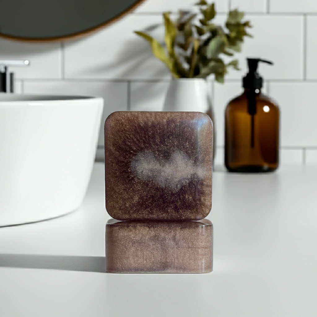 Noir Overture soap bars front and side on a white bathroom counter next to a sink.