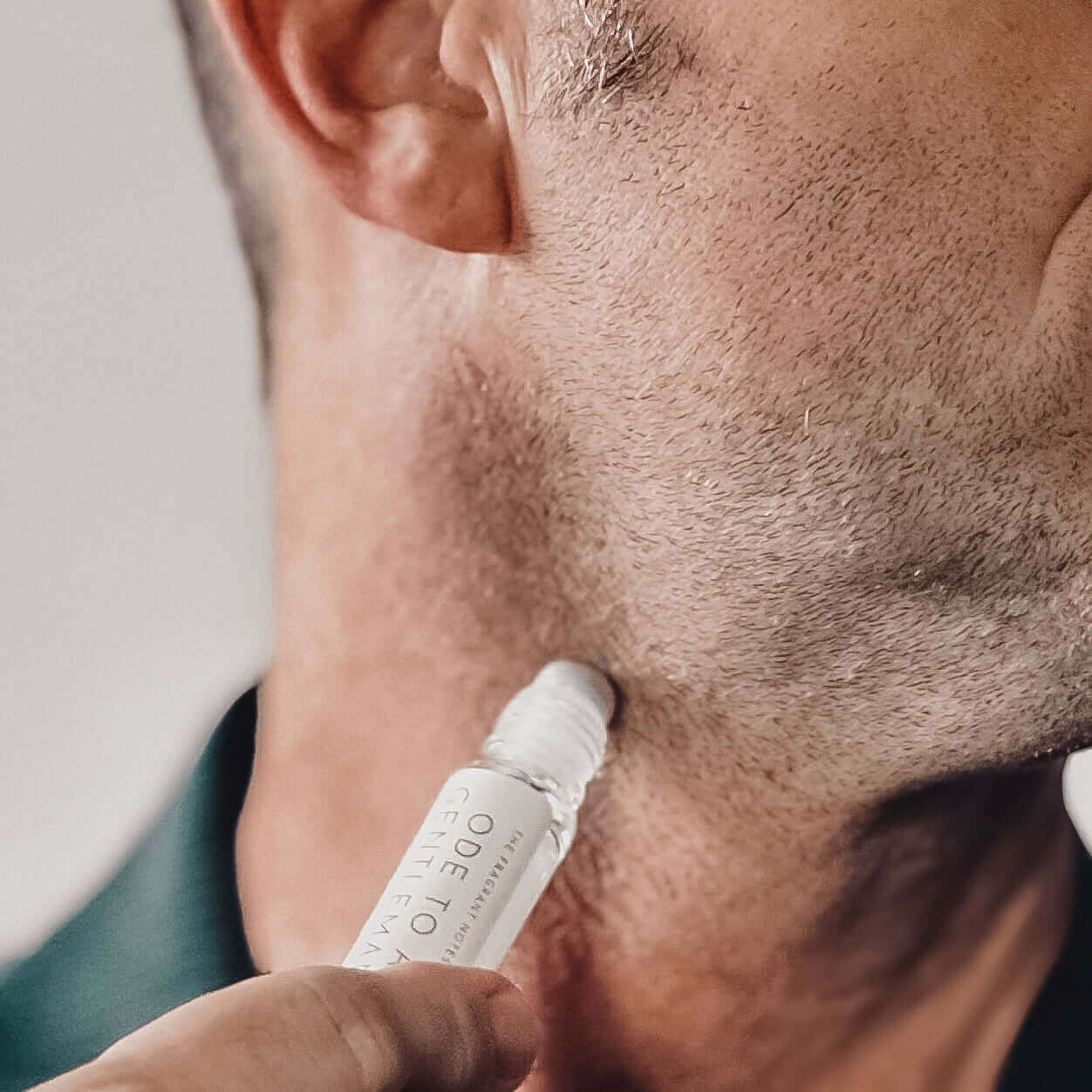 Up close of man using Ode To a Gentleman Roll-On Fragrance on his neck.