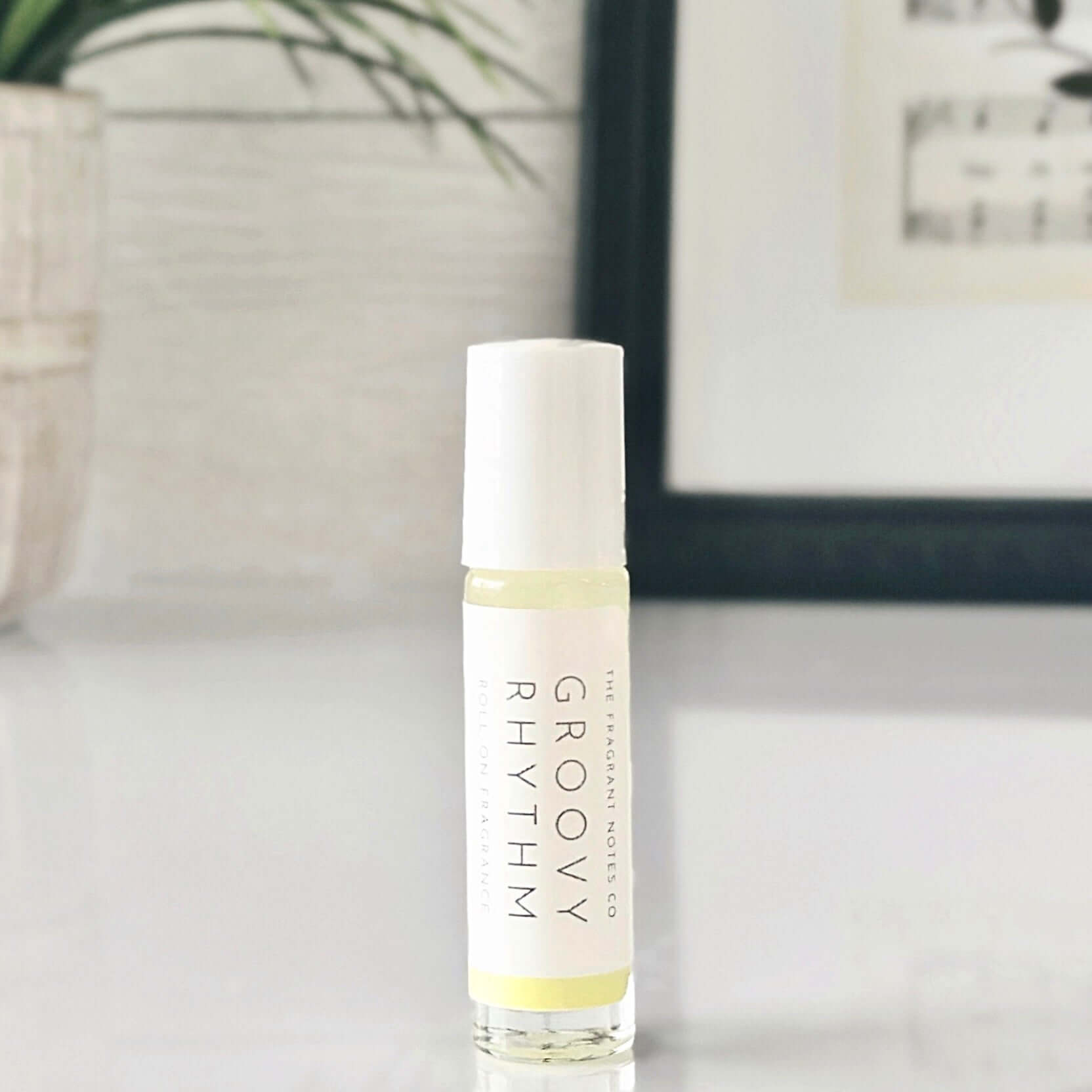 Groovy Rhythm Roll-On Perfume Oil standing up on white counter with plant in background