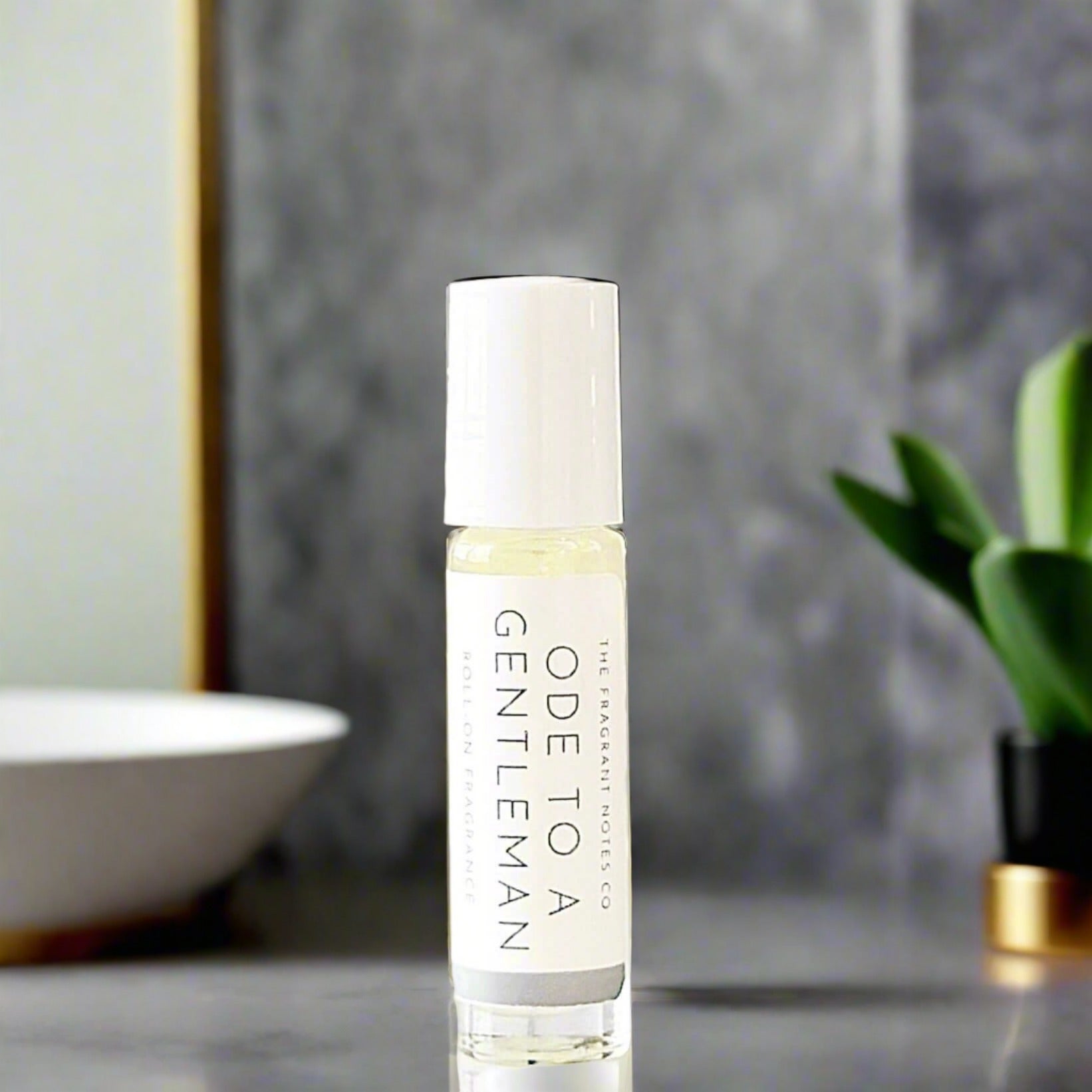 Ode To a Gentleman Roll-On Fragrance on a marble grey bathroom countertop.